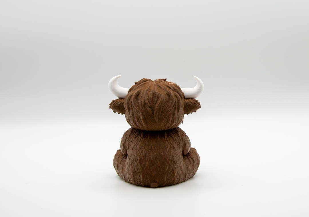 Udderly Done Highland cow ornament, back view showing shaggy coat and horns