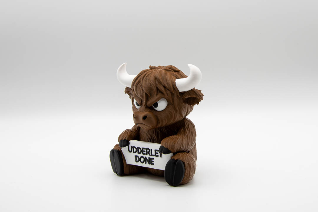 Udderly Done grumpy Highland cow ornament, angled view