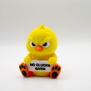 Grumpy yellow 3D printed chick holding a No Clucks Given sign