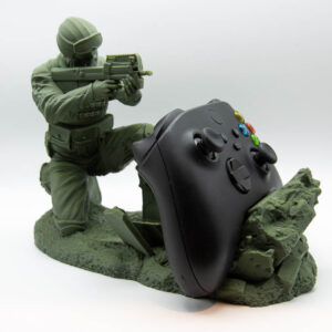 Green soldier controller holder with an Xbox controller resting behind the wall