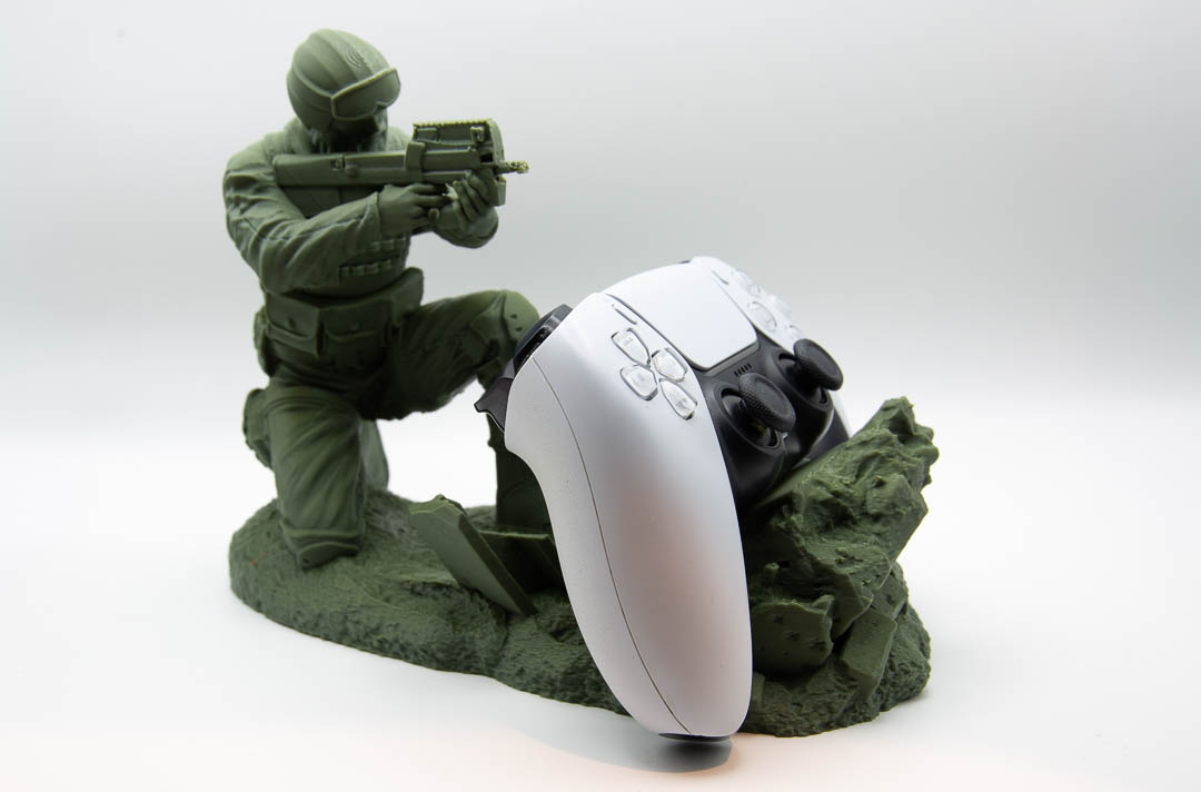 Green soldier controller holder holding a PS5 controller