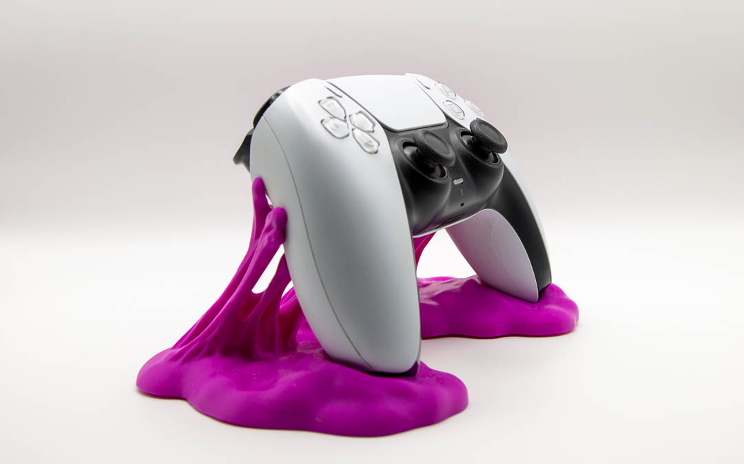 Magenta sticky slime controller holder with a PS5 DualSense controller