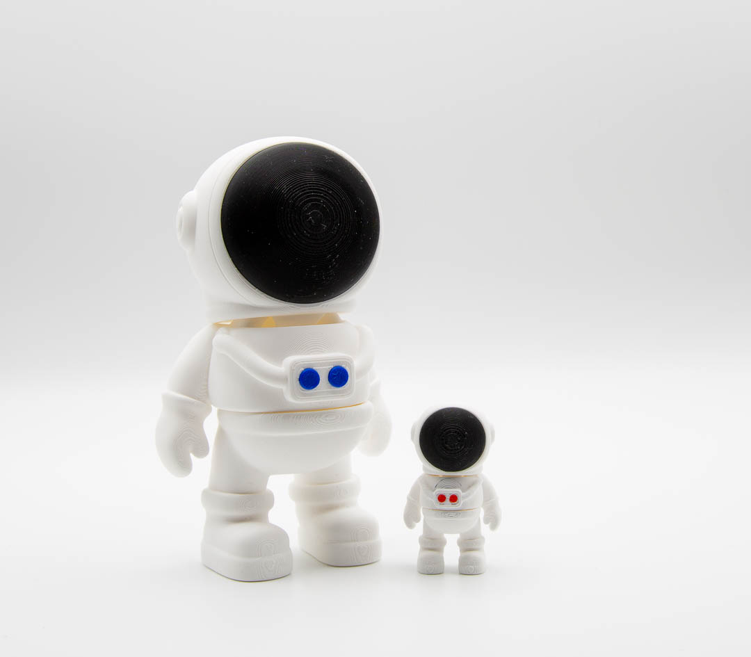 Flexi astronaut Mini Big next to a standard-size flexi astronaut for size comparison